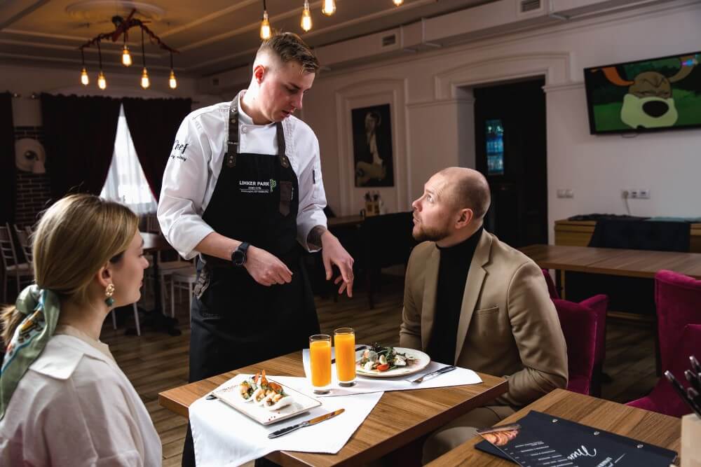 Шеф-повар ресторана Линкер Парк консультирует посетителей по составу предложенных блюд