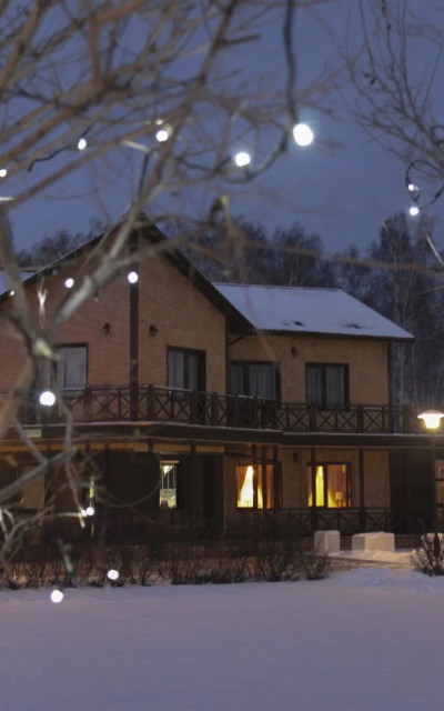 Коттедж в Линкер Парк в зимний вечер с чистым снегом и праздничной подсветкой для загородного отдыха в Омске